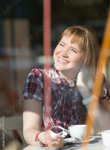 Woman drinking coffee in the morning in a restaurant, soft focus