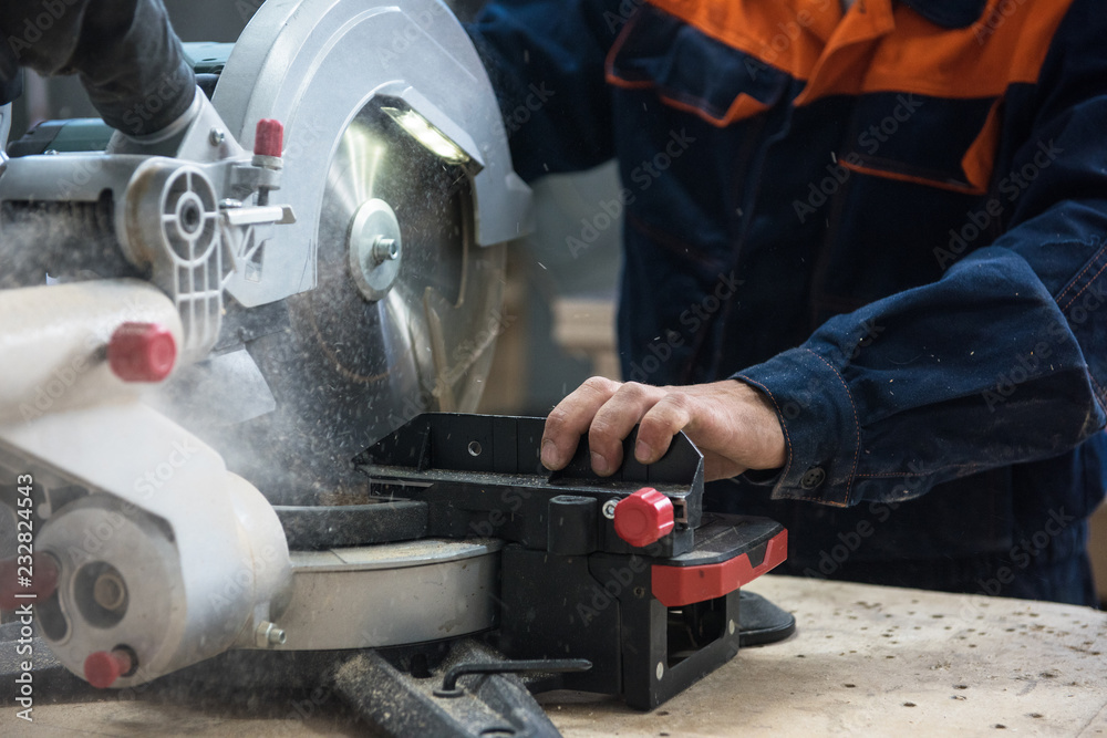 Furniture production or craft concept: worker making the wood surface of furniture part with special machine Furniture production or craft concept: worker making the wood surface of furniture part with special machine