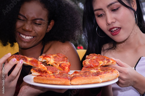 Friendship enjoy pizza on a table.
