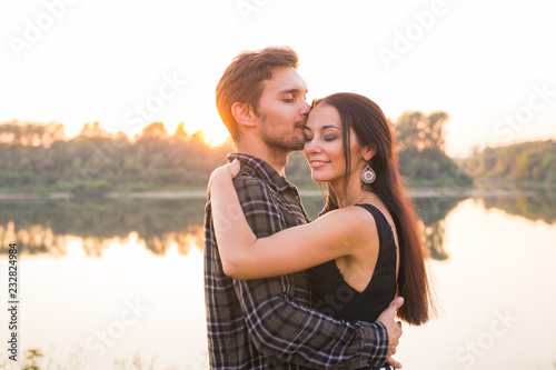 People, love and nature concept - Close up portrait of attractive woman and handsome man dancing on the background of threes and water