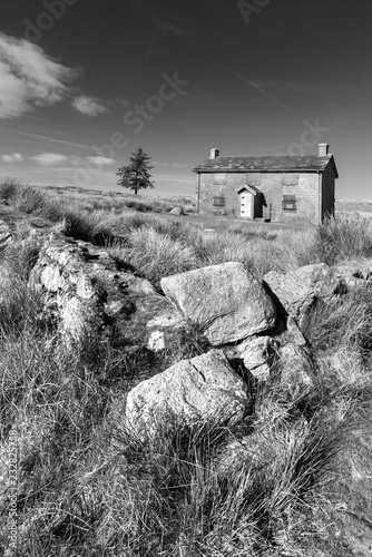 Stunning toned black and white landscape image of Nun's Cross Farm in Dartmoor