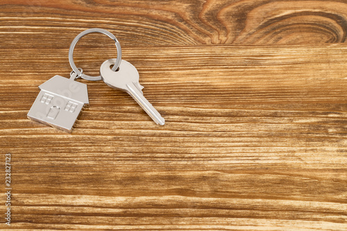 House key on wooden background concept for mortgage