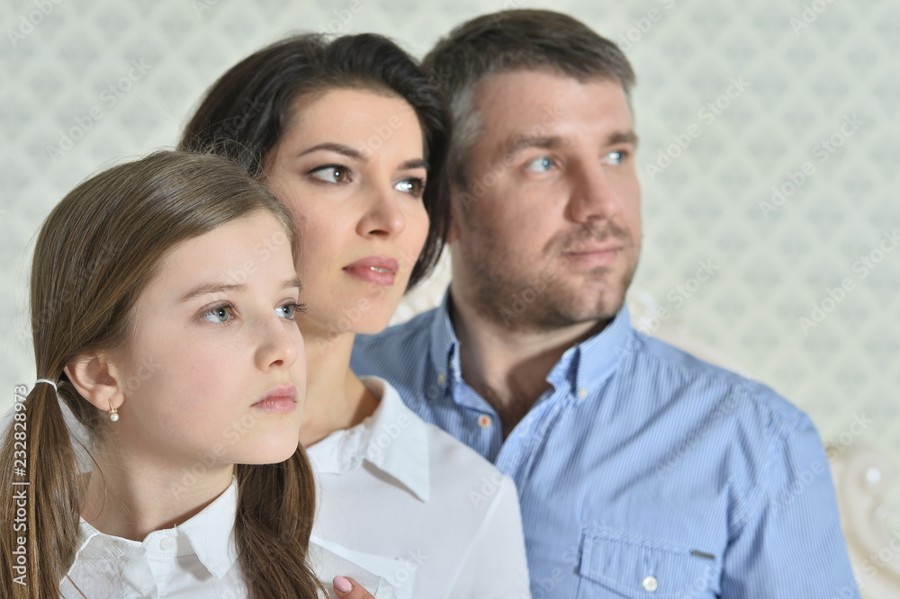 Portrait of a beautiful parents and daughter posing in room Portrait of a beautiful parents and daughter posing in room