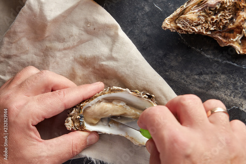 Billede på lærred Man opening fresh oyster
