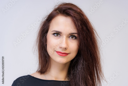 Studio portrait concept of a smiling beautiful brunette girl talking on a white background.