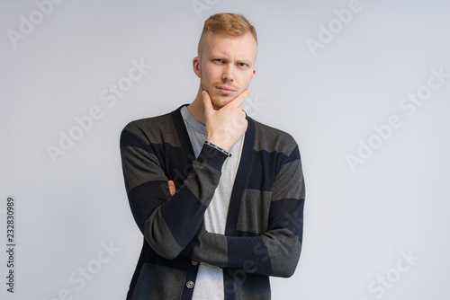 Studio portrait concept of a smiling young man talking on a white background.