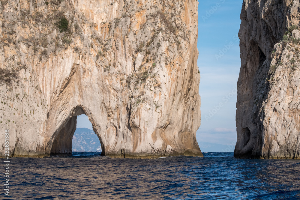 Iconic sea stacks and arch off the coast of Capri, Italy. They are named Stella, Faraglione di Mezzo with the arch, and Fraglione di Furori.