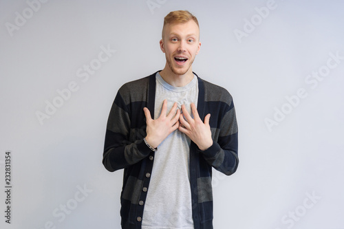 Studio portrait concept of a smiling young man talking on a white background.