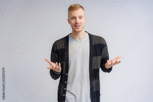 Studio portrait concept of a smiling young man talking on a white background.