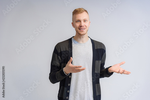 Studio portrait concept of a smiling young man talking on a white background.