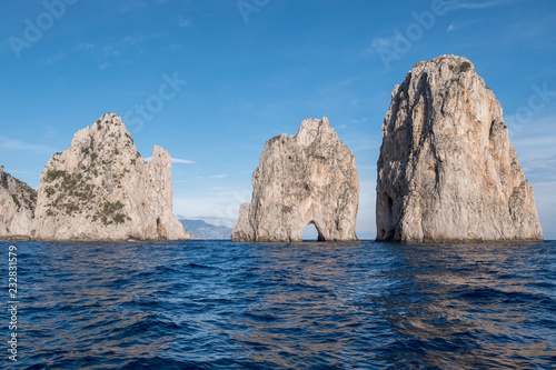 Sea stacks off the coast of Capri, Italy. They are named Stella, Faraglione di Mezzo with the arch, and Fraglione di Furori.