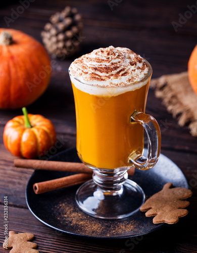 Pumpkin smoothie, spice latte. Boozy cocktail with whipped cream. Wooden background.