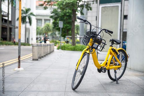 Yellow bike in public park building background and view landscape of commercial building in central city