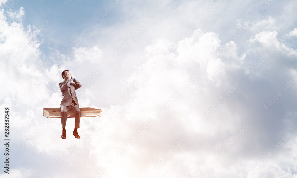 Young man on book in blue sky do not want to see anything Young man on book in blue sky do not want to see anything