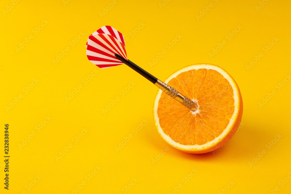 orange slice, fruit with circular target marked and dart on yellow background. minimal idea food and fruit concept. Idea creative to produce work and advertising marketing communications - obrazy, fototapety, plakaty 