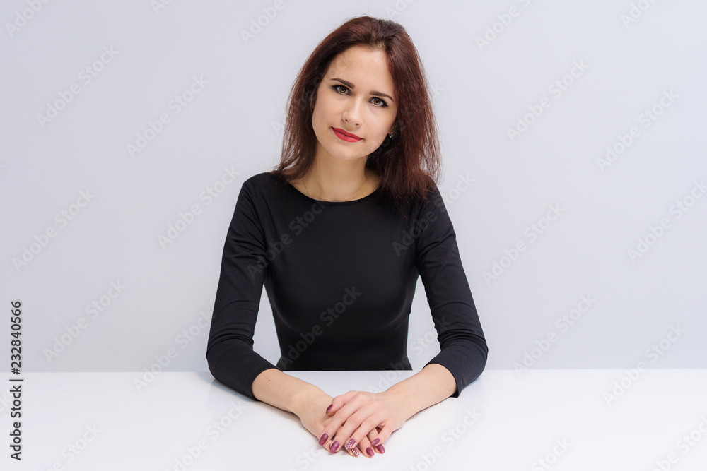 Concept of beautiful brunette girl talking on a white background at the table. Concept of beautiful brunette girl talking on a white background at the table.
