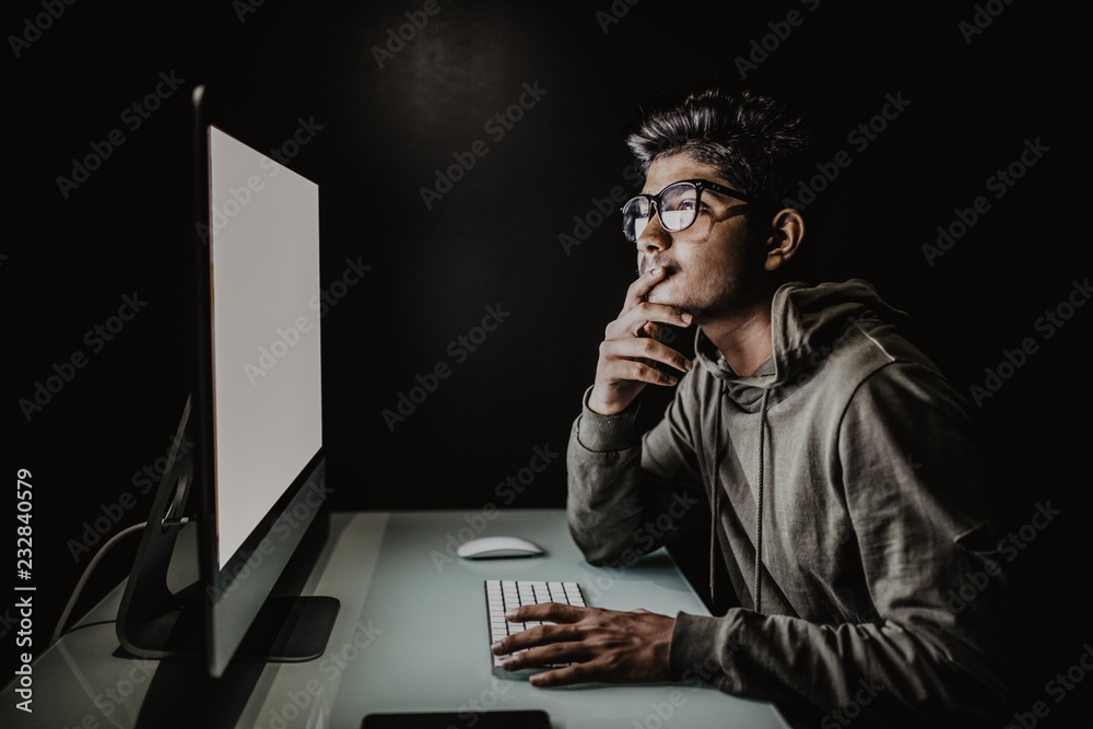 Indian hacker using computer white screen trying to commit computer crime. Hacker and computer threat crime concept Indian hacker using computer white screen trying to commit computer crime. Hacker and computer threat crime concept