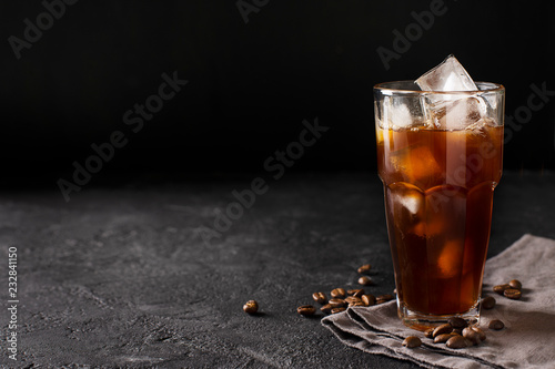 Canvas Print tall glass cold brew coffee with ice on black or dark background