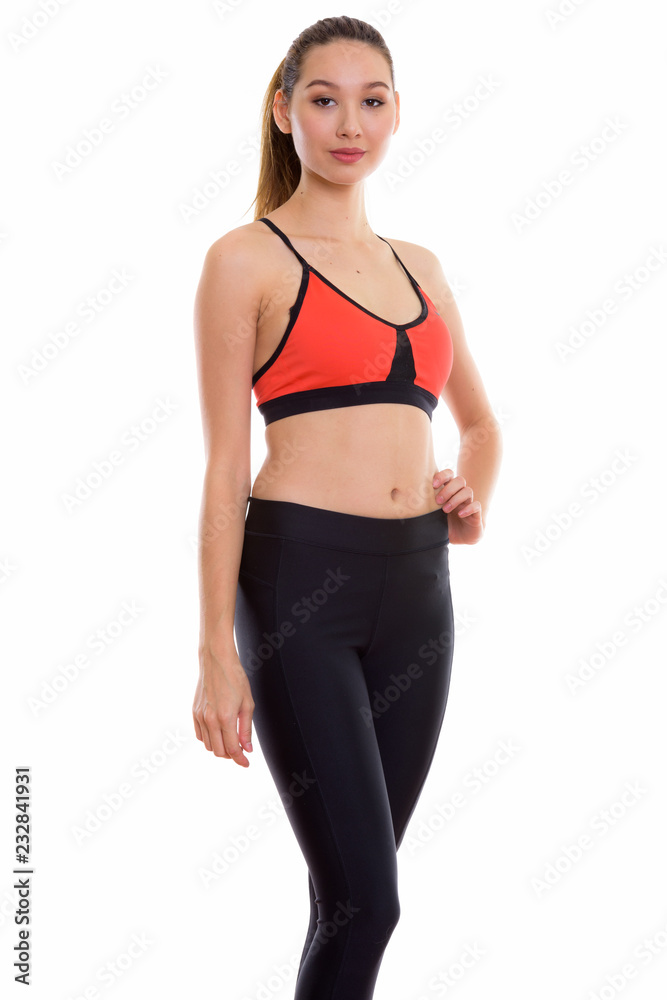 Studio shot of young beautiful Asian woman standing while posing Studio shot of young beautiful Asian woman standing while posing