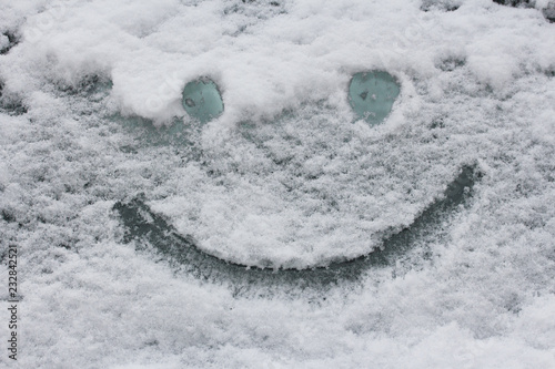 Smiley face on snow surface. Winter concept. © oxxyzay