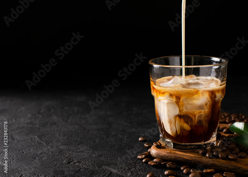 Schilderij op canvas glass cold brew coffee with ice and milk on black or dark background