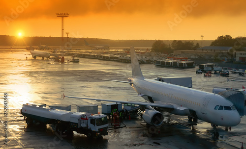the plane at the airport is preparing to take off is fueling and loading baggage