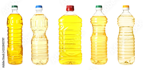 Set with plastic bottles of oil on white background