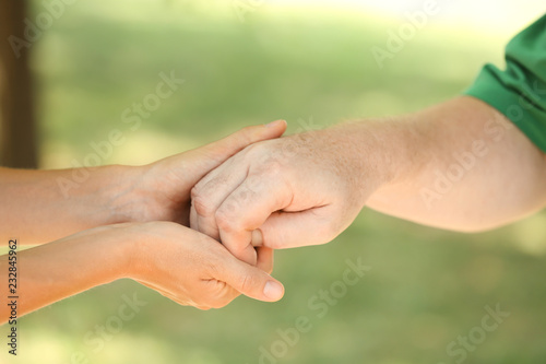Helping hands on blurred background, closeup. Elderly care concept © New Africa