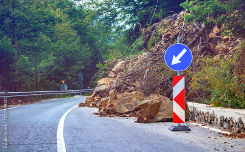 rockfall on the road, stones collapse.  warning sign