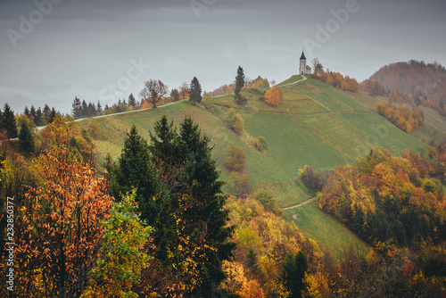 Small romantic church on the top of the hill in rainy colorful autumn nature. Jamnik, Slovenia , Europe