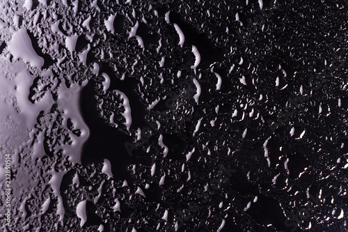 water drops on a black background with the reflection of light spots