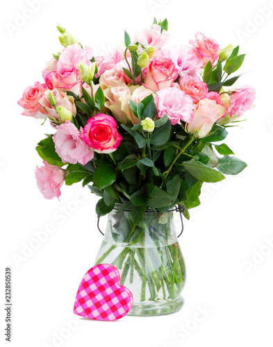 Rose and eustoma fresh flowers bouquet in two shades of pink in glass vase isolated on white background