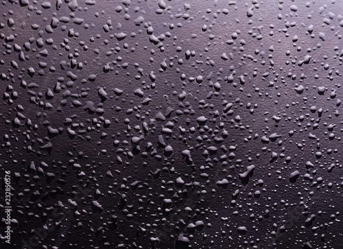 water drops on a black background with the reflection of light spots