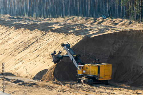 Heavy excavator in sand quarry, mining industry