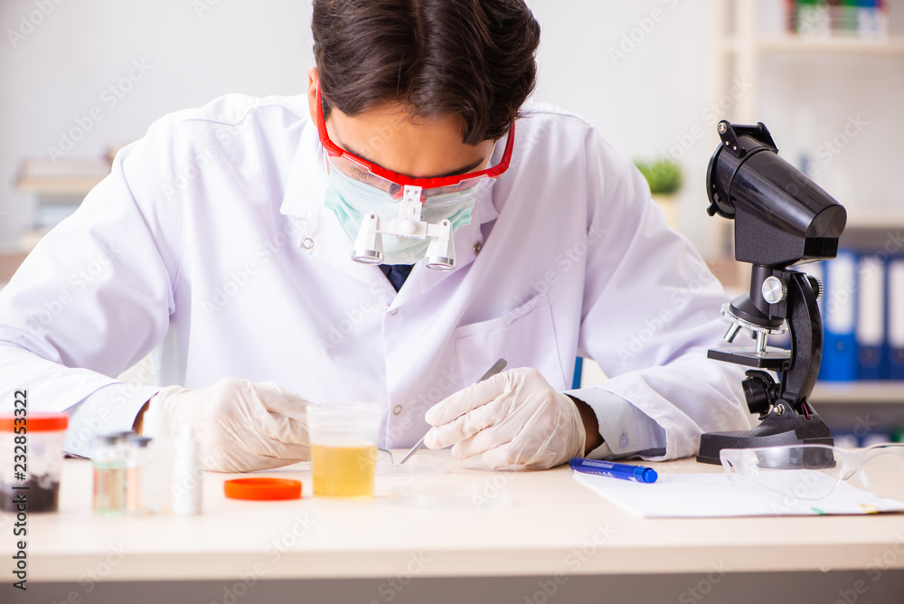 Young handsome chemist working in the lab