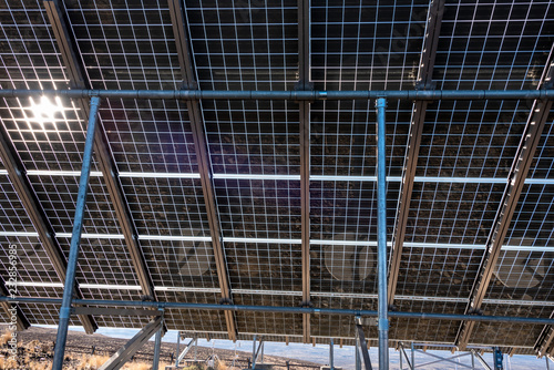 Close up of underside of solar panel installation in a dry landscape