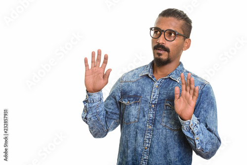 Young Indian man looking shocked studio portrait against white background