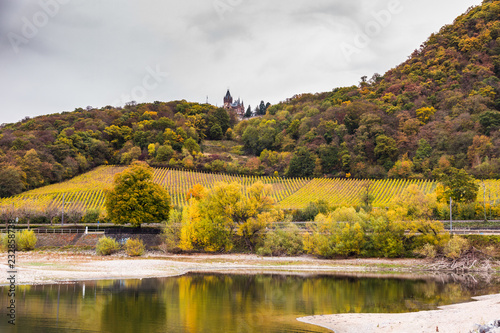 Beautiful autumn landscape with Schloss Drachenburg Castle - partly hidden by hills - in Konigswinter on the Rhine river near the city of Bonn in Germany photo