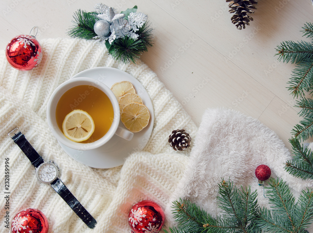 Top view cup of tea decorated with knitted scarf, fir branches and pine cones. Christmas winter mood. Flat lay Top view cup of tea decorated with knitted scarf, fir branches and pine cones. Christmas winter mood. Flat lay