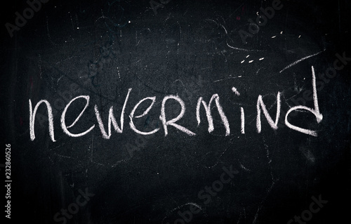 Canvastavla word nevermind written in white chalk on a school blackboard