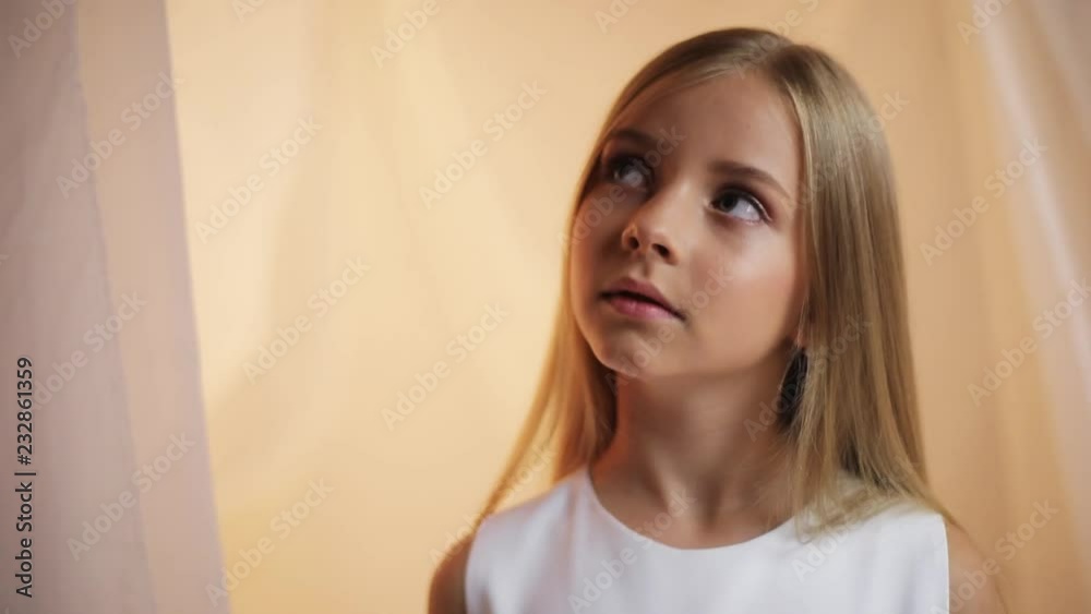 Portrait little girl with a make-up turns his head and looks to the camera talk angry sad serious stand indoors cute young attractive blonde hair beautiful caucasian female pretty slow motion Portrait little girl with a make-up turns his head and looks to the camera talk angry sad serious stand indoors cute young attractive blonde hair beautiful caucasian female pretty slow motion