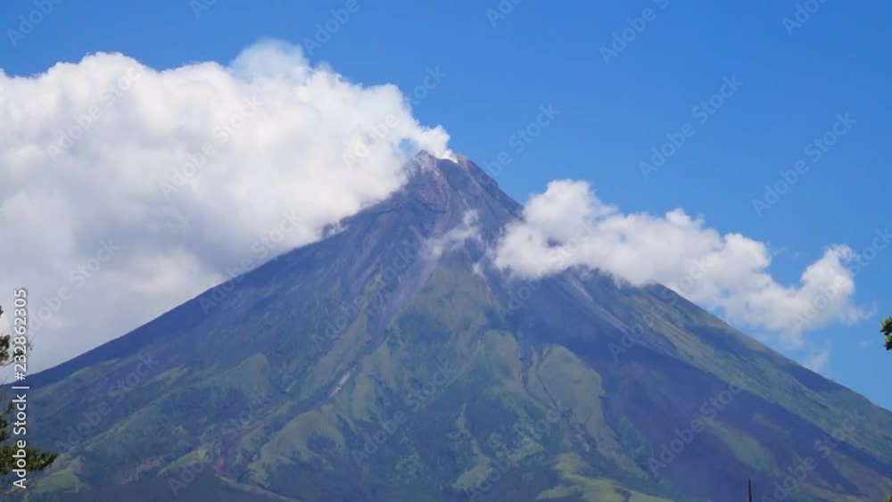 White ash clouds emit from Mayon volcano crater on a clear day White ash clouds emit from Mayon volcano crater on a clear day