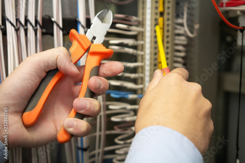 Obraz na płótnie Electric tools in hands of electrician in electrical fuse box. w salonie