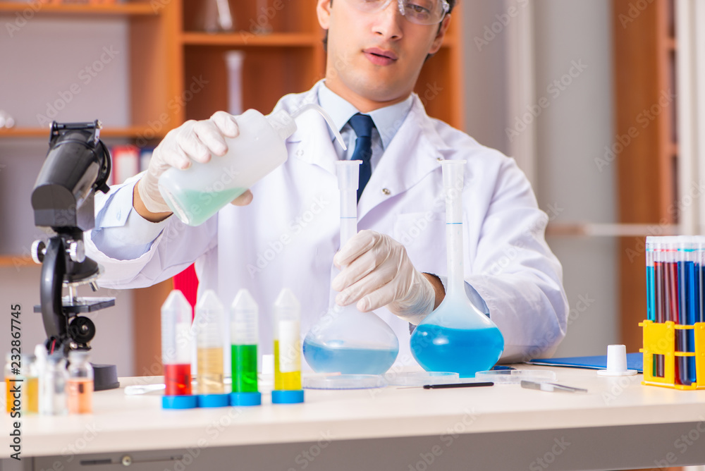 Fototapeta premium Young handsome biochemist working in the lab 
