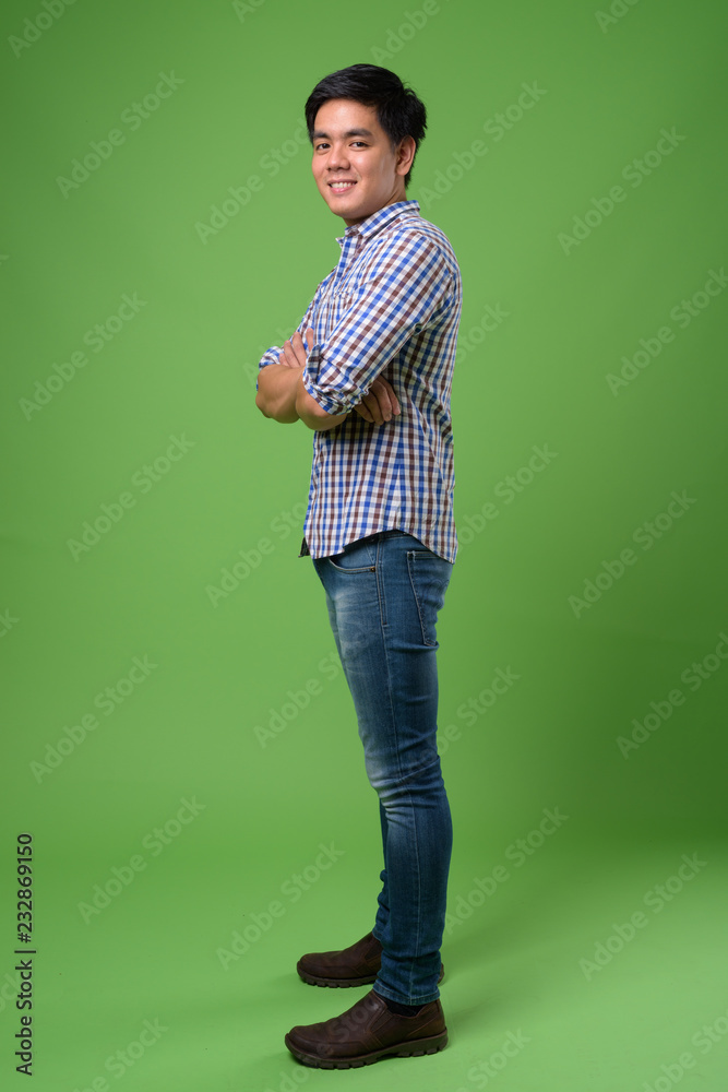 Young handsome Filipino man against green background Young handsome Filipino man against green background