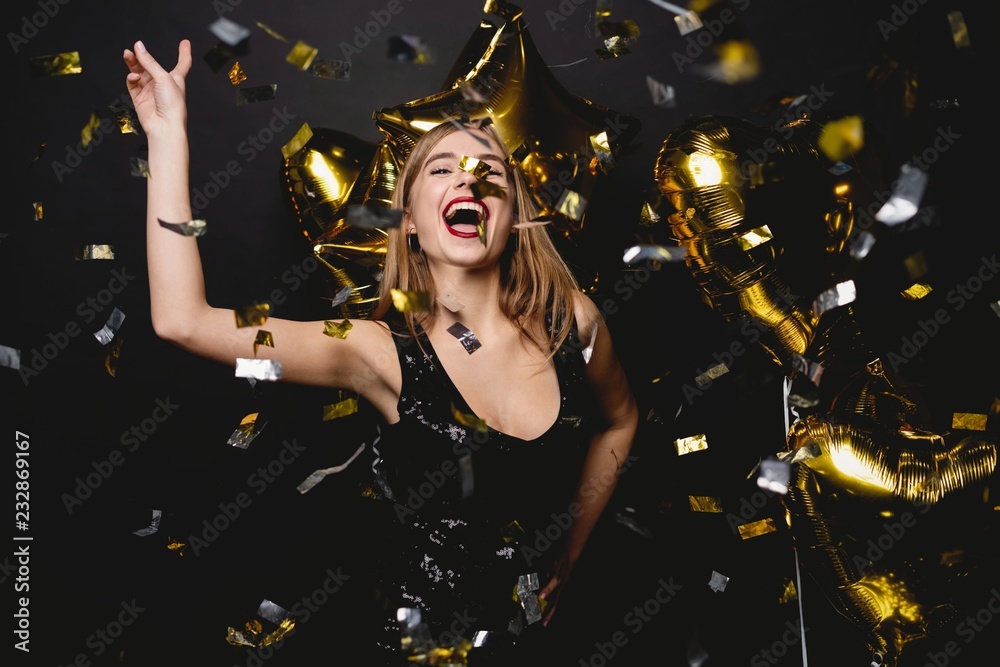 Cheerful woman with balloons laughing on black background. - obrazy, fototapety, plakaty 