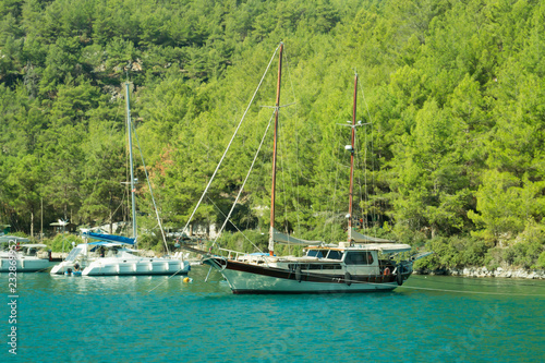 Recreation on the boat near the shore of a mountain and forest. Ship in the bay. summer vacation travelling