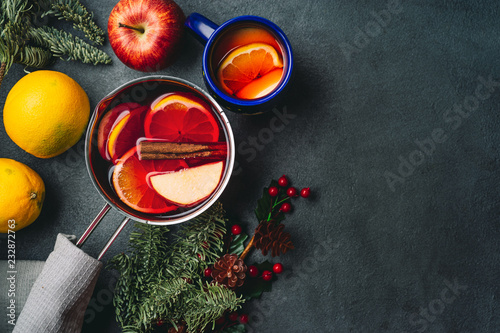 Top view of mulled wine in a pot on dark background