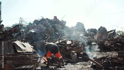 Worker cuts metal with a gas cutter on a srap yard for recycling purposes