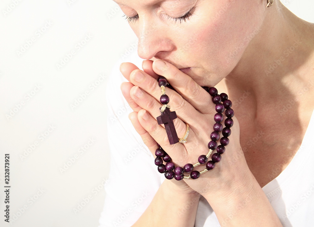 woman praying with cross in her hands